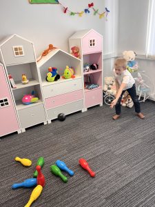 Chłopiec bawiący się w kręgle podczas zajęć ruchowych w Akademii LOOK w Katowicach, w kolorowym gabinecie terapeutycznym